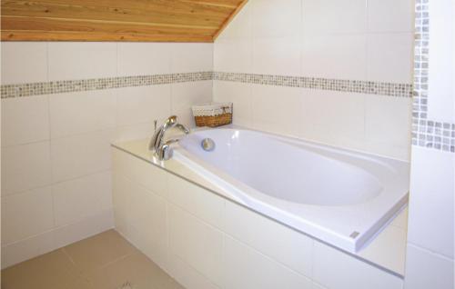 baño con bañera blanca y techo de madera en Awesome Home In Rybakowo With 3 Bedrooms, en Rybakowo