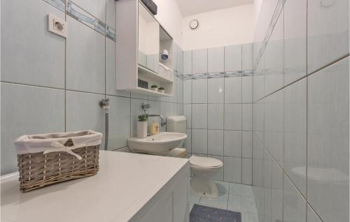 a white bathroom with a toilet and a sink at Nice Apartment In Pula With 3 Bedrooms And Wifi in Pula