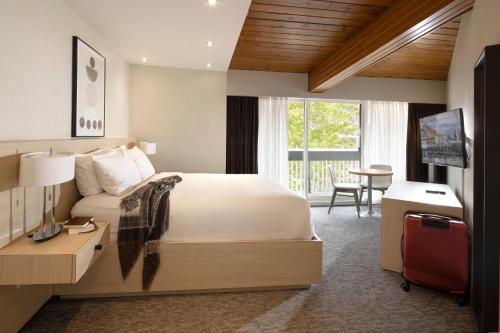 a bedroom with a bed and a desk and a television at Banff Aspen Lodge in Banff