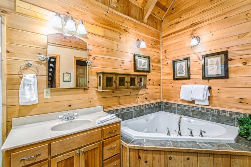a bathroom with a tub and a sink and a mirror at McCormack's Mill in Pigeon Forge