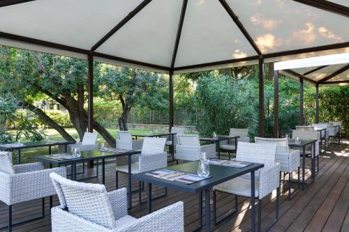 a restaurant with tables and white chairs on a deck at Best Western Park Hotel Continental in San Donà di Piave