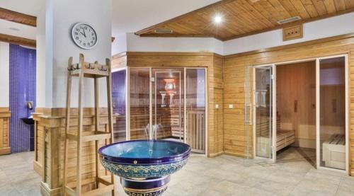 uma grande casa de banho com uma banheira com um relógio na parede em Pirin Golf Downtown em Razlog