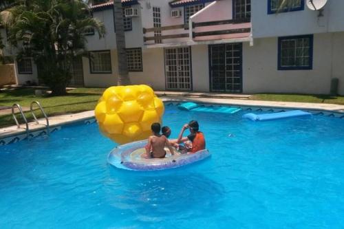 two people in a pool with a float in the water at Casa en la zona de Acapulco diamante in La Sabana