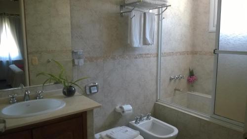 Un baño con lavabo, inodoro y ducha. en Casa Celeste, en Valeria del Mar