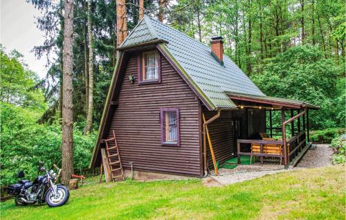 a small house with a motorcycle parked in front of it at Holiday Home Barczewo Kaplityny Vi in Bogdany