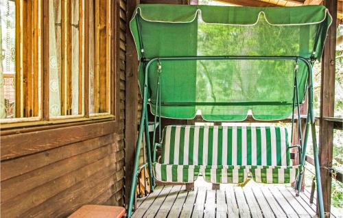 a green chair sitting on a porch next to a window at Holiday Home Barczewo Kaplityny Vi in Bogdany
