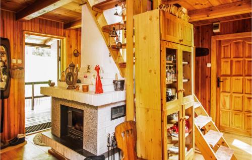 a living room with a fireplace and wooden walls at Holiday Home Barczewo Kaplityny Vi in Bogdany