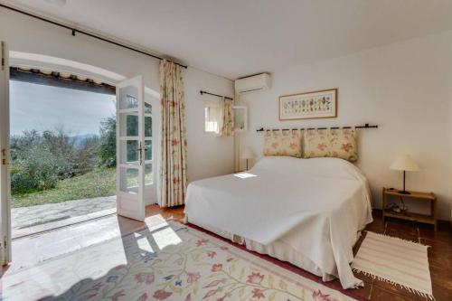- une chambre avec un lit et une grande fenêtre dans l'établissement L'Olivette - Mas Provencal, Panoramic View & Pool, à Callian