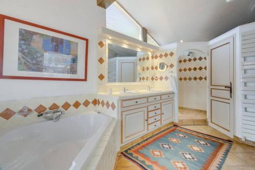 La salle de bains est pourvue d'une baignoire, d'un lavabo et d'un miroir. dans l'établissement L'Olivette - Mas Provencal, Panoramic View & Pool, à Callian