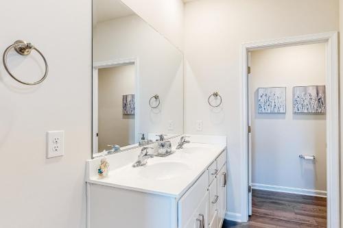 a white bathroom with a sink and a mirror at Millville by the Sea --- 36603 Calm Water Drive in Millville