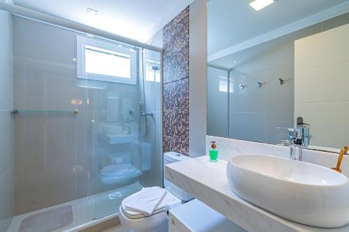 une salle de bain avec un lavabo, une douche et des toilettes dans l'établissement Excelente no Centro de Canela @stayhousetemporada, à Canela