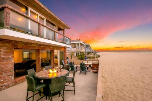 a patio with a table and chairs on the beach at Newport Beach Front View I in Newport Beach