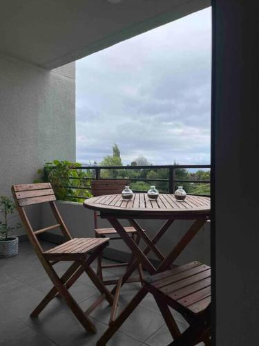 a wooden table and two chairs on a balcony at Hermoso departamento con vista al mar in Tomé