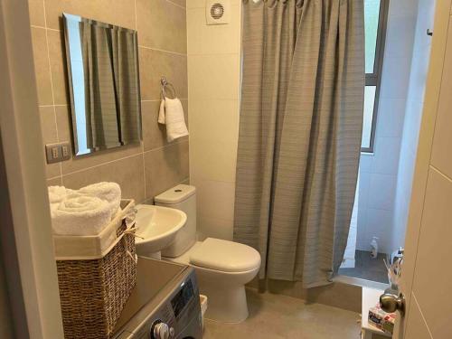 a bathroom with a toilet and a sink and a shower at Hermoso departamento con vista al mar in Tomé