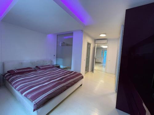- une chambre avec un lit et un plafond violet dans l'établissement Central apartament Bulevardul Decebal, à Bucarest