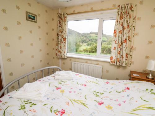 a bed in a bedroom with a window at Llwynon in Aberystwyth