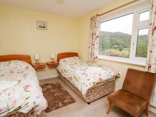 a bedroom with two beds and a window at Llwynon in Aberystwyth