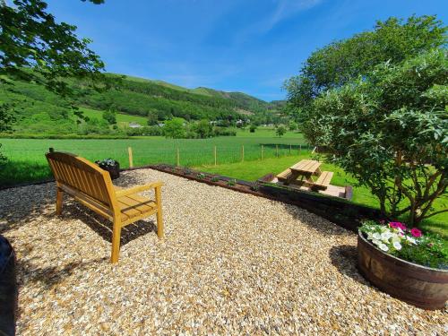 a wooden bench sitting on top of a gravel yard at Llwynon in Aberystwyth