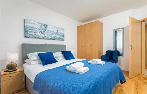 una camera da letto con un letto blu e bianco con asciugamani di Stunning Apartment In Valbandon With Wifi a Fažana