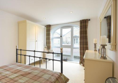 a bedroom with a bed and a large window at Bucklaw Cottage in Alnwick