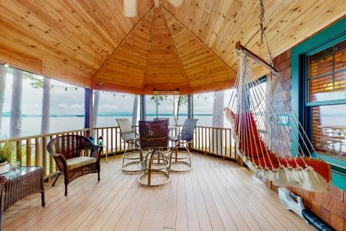 a porch with a hammock and a swing at Alton Bay Lakefront Beauty in Alton Bay