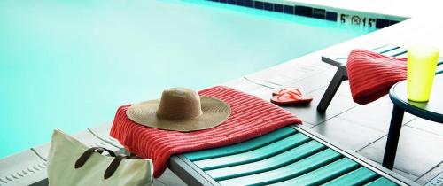 un sombrero sentado en una silla junto a una piscina en Home2 Suites By Hilton Covington, en Covington