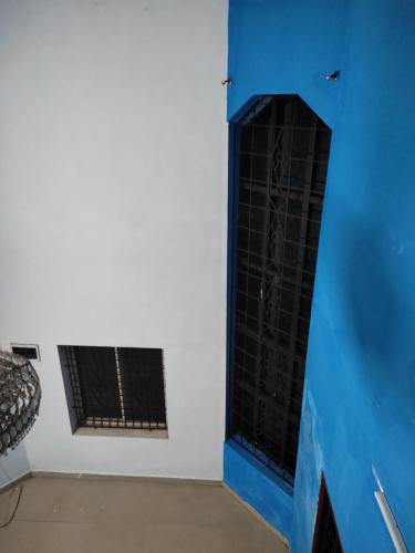 a room with a blue and white wall and a window at Gruham Malpe Homestay Udupi in Malpe