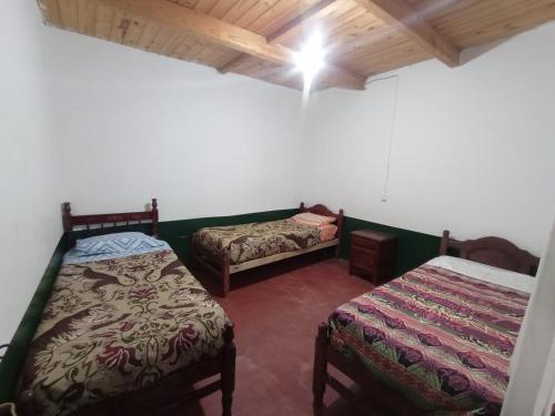 a room with two beds in a room at HOSTAL LUPITA in Iruya