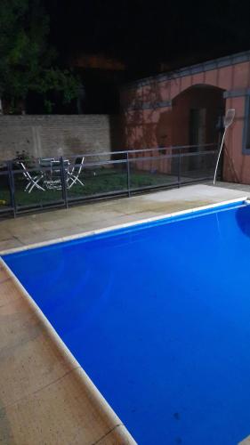 una gran piscina azul en un patio en Casa vero en San Antonio de Areco
