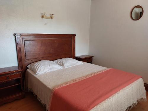 1 cama con cabecero de madera en un dormitorio en La Ginelle - Appartement Terrasse en Airoux