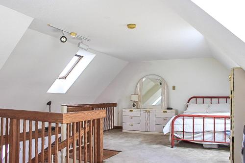 Dormitorio en el ático con cama y espejo en South Down's Delight, en Laconia
