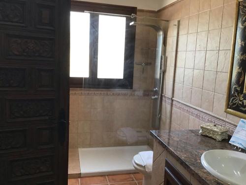 La salle de bains est pourvue d'une douche, d'un lavabo et de toilettes. dans l'établissement Luxury Spanish Country House close to Granada & Sierra Nevada, à Ermita Nueva