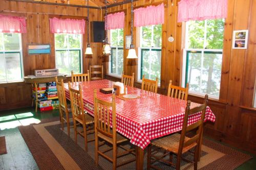 a dining room with a red and white table and chairs at Cottage on Geneva Point in Moultonborough