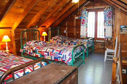a room with four beds in a wooden cabin at Cottage on Geneva Point in Moultonborough