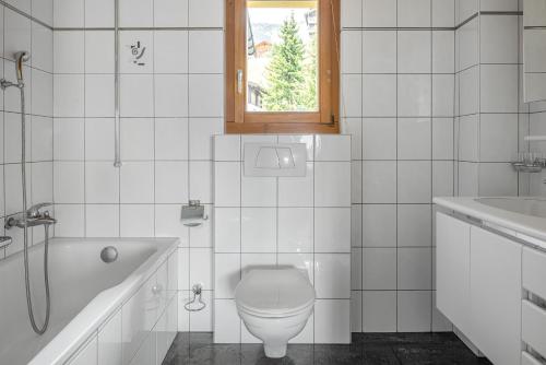 een badkamer met toilet, bad en wastafel bij Alpengarten 7 in Bettmeralp