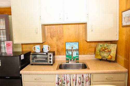 a kitchen with a sink and a microwave at Varney Point Studio in Gilford