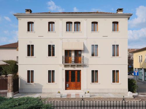 a white house with a red door and a balcony at VILLA MARGHERITA in Pieve di Soligo