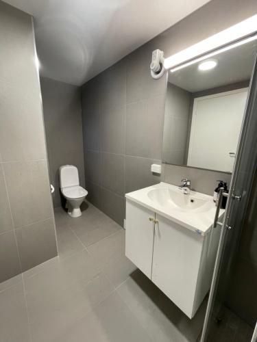 une salle de bain avec un lavabo blanc et des toilettes dans l'établissement The Black Door., à Stavanger