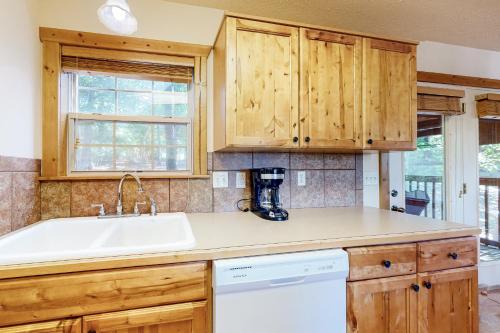 a kitchen with wooden cabinets and a sink at Beautiful Branson in Branson West