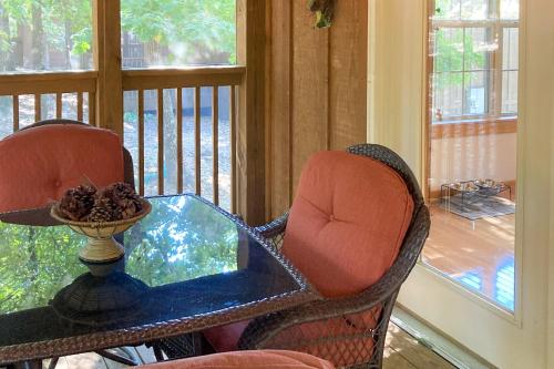 a table and two chairs on a porch with a window at Beautiful Branson in Branson West
