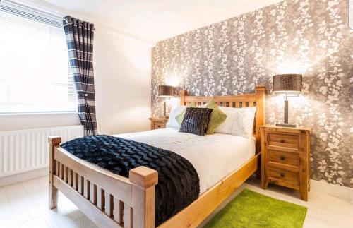 una camera con letto in legno e tappeto verde di Victoria Place apartment a Belfast