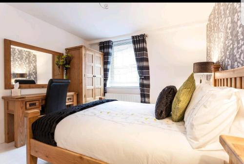 a bedroom with a bed with a desk and a chair at Victoria Place apartment in Belfast