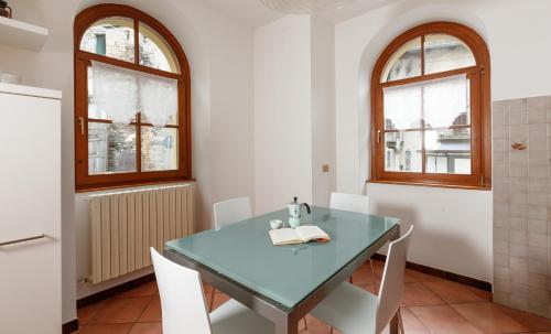 cocina con mesa azul y sillas blancas en IL COM0' DELLA CIVETTA - La casa di Dorina, en Stazzona