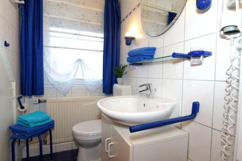 ein Badezimmer mit einem Waschbecken, einem WC und einem Spiegel in der Unterkunft Ferienwohnung Doris in Norddeich