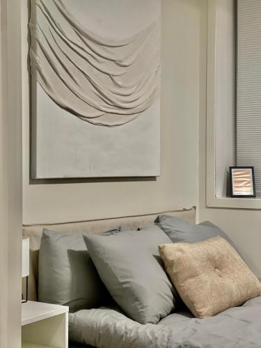 a bedroom with a bed with pillows and a painting at The Black Door. in Stavanger