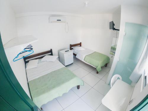 - une salle d'hôpital avec 2 lits et un miroir dans l'établissement HOTEL MORADA DO SOL, à Pontal do Paraná