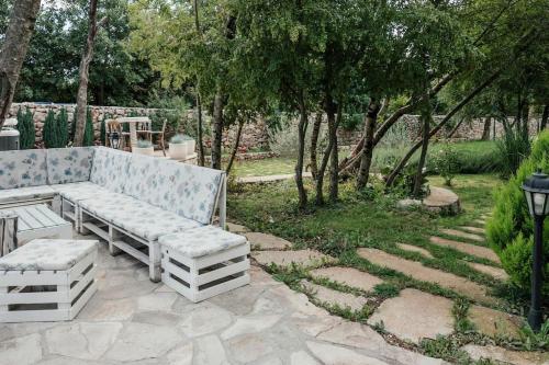 a white bench sitting on a stone patio at VILLA G., Relaxing and Unique nest of Enjoyment in Imotski