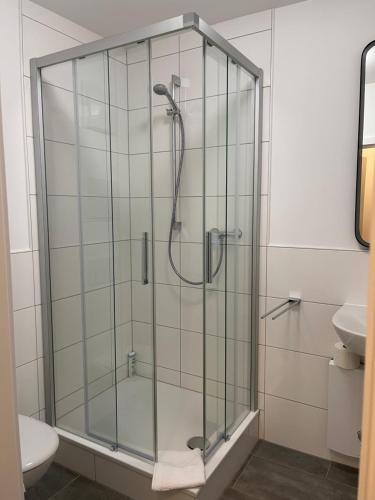 a glass shower in a bathroom with a toilet at Weseler Wirtshaus Appartements in Wesel