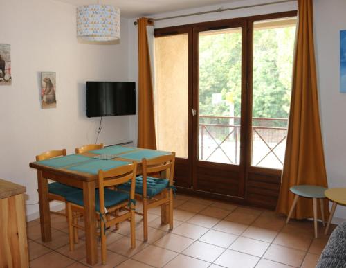 a dining room with a table and chairs and a balcony at Appartement au départ des remontées mécaniques - Briançon in Briançon