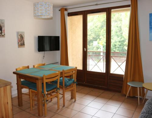 jadalnia ze stołem i krzesłami oraz balkonem w obiekcie Appartement au départ des remontées mécaniques - Briançon w mieście Briançon